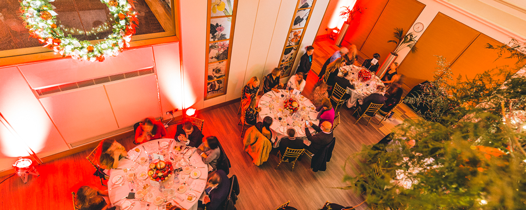birds eye view photo of people eating and enjoying a sit down meal for a christmas party