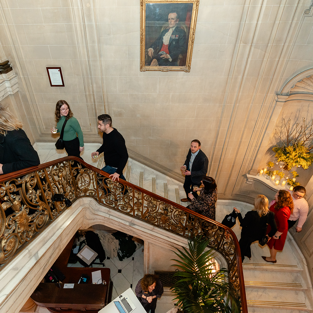 people walking up a grand hallway staircase ready for a christmas party event
