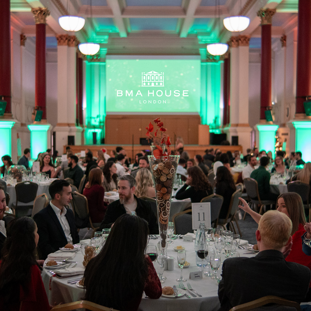 people sat around a dinner table at christmas for a corporate christmas party event