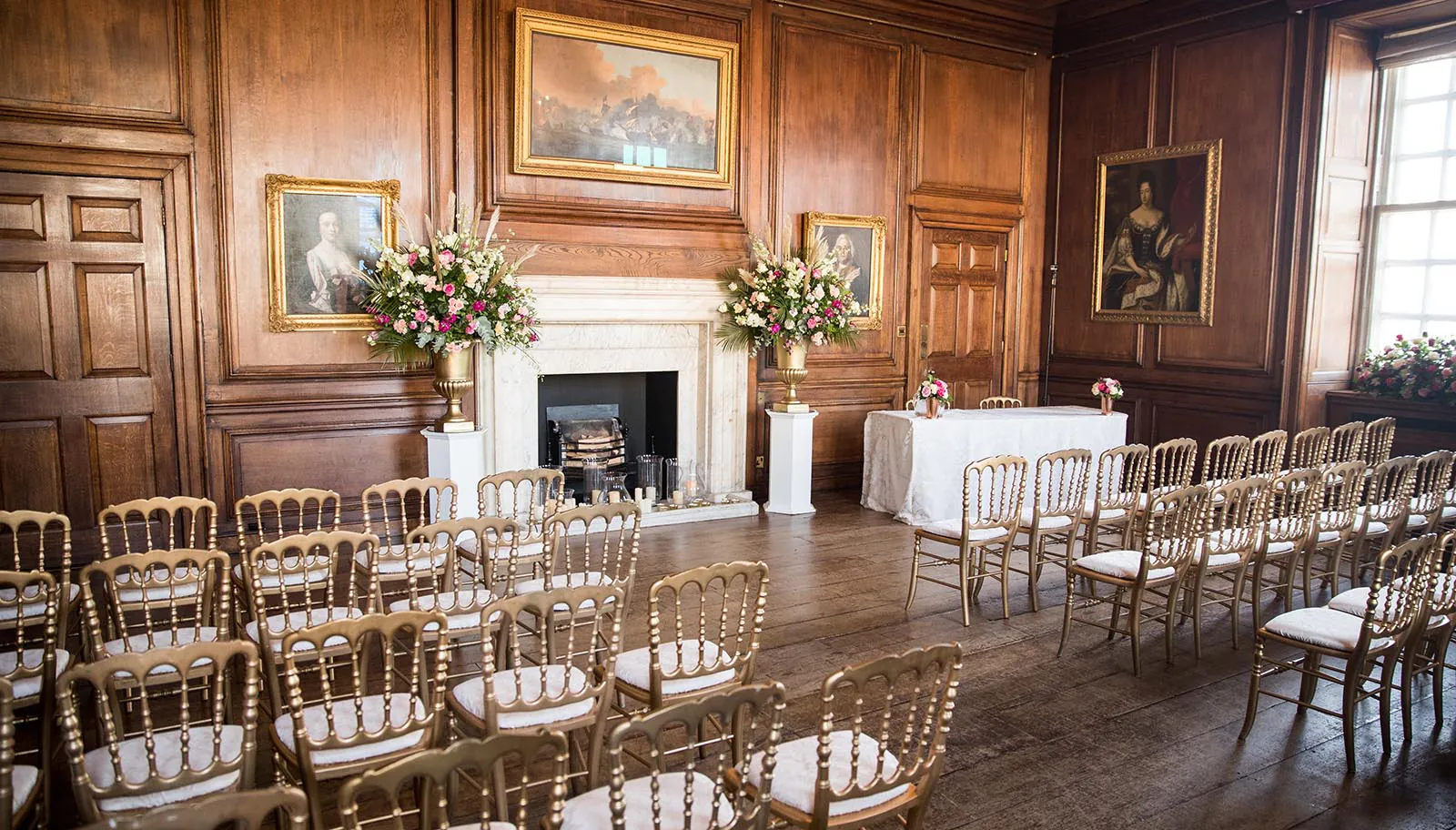 Empty room with paintings and chairs and a aisle int he middle